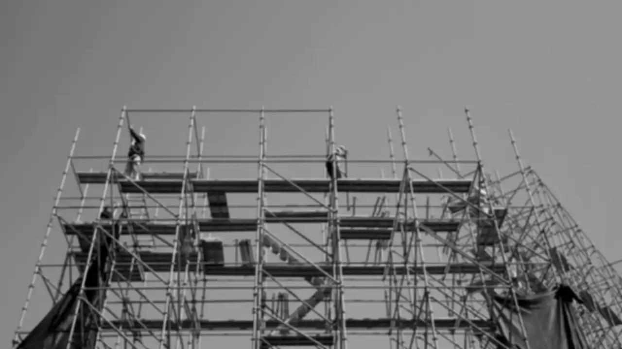Workers on scaffolding against a clear sky